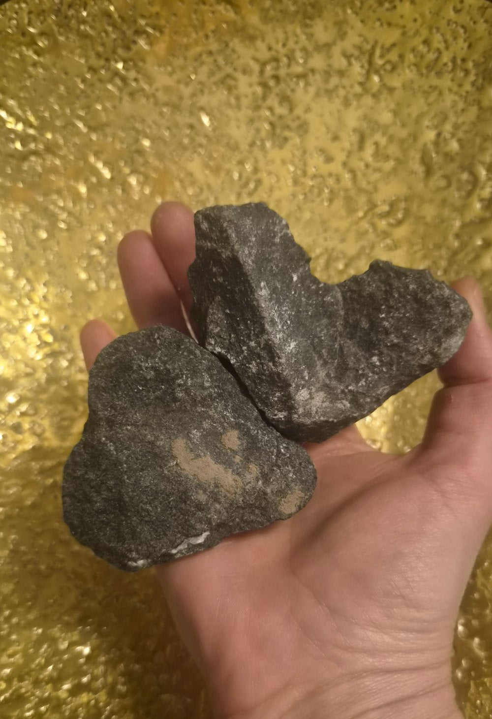 Zwei herzförmige Steine in einer Hand